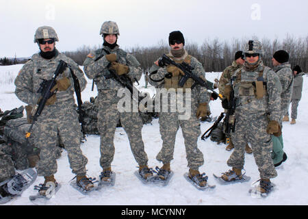 Von links nach rechts, Alpha Team Leader Sgt. Taylor Tobar stellt mit seinen Truppen SPC. Travis Smith, eine Säge Gunner, SPC. Doug Brown, rifleman und SPC. Santo Griego, ein grenadier, bevor sie sich in einer Live-fire Übung am 3. März. Wyoming Soldaten aus C Company, 1 Battalion, 297Th Infanterie Regiment beteiligten sich an der Arktis Eagle 2018 Februar 20. bis 8. März für das jährliche Training. Es war das erste Mal, dass Sie mit Soldaten aus der Elterneinheit in Alaska auf Basis ausgebildet. Stockfoto