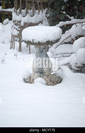 Wintergarten Szene ein Vogelbad mit Schnee bedeckt. Eiskalt Wetter. Stockfoto