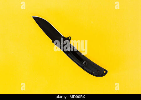 Taschenmesser schwarz auf gelbem Hintergrund. Stockfoto