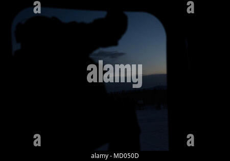 Us-Armee Soldat Cpl. Marcus Gadsden mit Bravo Company, 1-52 nd Aviation Regiment, beaufsichtigt von einem Chinook CH-47in Fort Greely, AK, am 12. März 2018. Arctic Edge 2018 Ist eine Biennale, groß angelegte, gemeinsame Ausbildung übung, bereitet und testet die Fähigkeiten des US-Militärs in den arktischen Umgebungen. (U.S. Marine Corps Foto von Cpl. Bethanie Ryan) Stockfoto