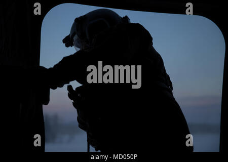 Us-Armee Soldat Cpl. Marcus Gadsden, Bravo Company, 1-52 nd Aviation Regiment, beobachtet die Landung eines Chinook CH-47im Fort Wainwright, AK, am 12. März 2018. Arctic Edge 2018 Ist eine Biennale, groß angelegte, gemeinsame Ausbildung übung, bereitet und testet die Fähigkeiten des US-Militärs in den arktischen Umgebungen. (U.S. Marine Corps Foto von Cpl. Bethanie Ryan) Stockfoto