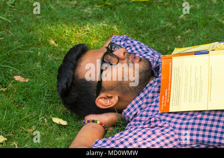 Jungen Mann liegen auf Gras und Ruhephase nach dem Lesen Stockfoto