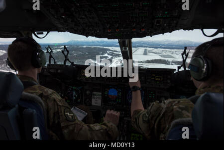 Us-Luftwaffe Kapitän Alex Hoffman (links), 7. Airlift Squadron Pilot, und Kapitän Richard Elliot, 8. Airlift Squadron Fluglehrer, beginnen Sie eine anständige in einem C-17 Globemaster III Eielson Air Force Base, Alaska, 11. März 2018. Die Flieger auf der 62. Airlift Wing zugeordnet Eielson flog als Teil der Übung Arktis Pegasus kalt zu üben - Wetter. Stockfoto