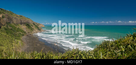 Abgelegener Strand mit vulkanischem Sand und türkisfarbenem Wasser. Es liegt in der Gegend von Muriwai, nicht weit von Auckland, Neuseeland Stockfoto