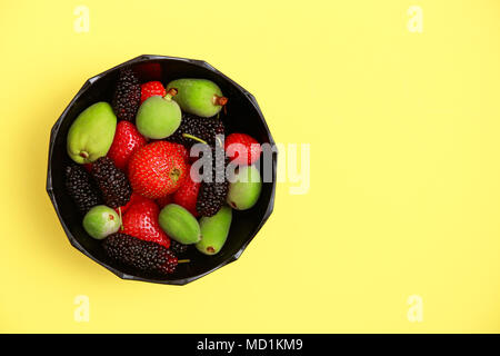 Lecker mit Sommer Früchte auf einem frischen Gelb flachbild Hintergrund legen. Kirsche, Brombeere, Erdbeere im servierteller. Startseite flache Ansicht Stockfoto