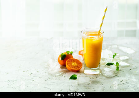 Orangensaft mit Eis und Mandarinen auf weißem Hintergrund. Freier Platz für Ihren Text. Copyspace. Kalte Getränke an heißen Sommertagen. Stockfoto