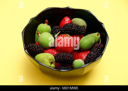 Lecker mit Sommer Früchte auf einem frischen Gelb flachbild Hintergrund legen. Kirsche, Brombeere, Erdbeere im servierteller. Startseite flache Ansicht Stockfoto