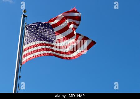 Amerikanische Flagge am Fahnenmast bei voller Mast auf Breezy sonnigen Tag gegen den strahlend blauen Himmel isoliert Stockfoto