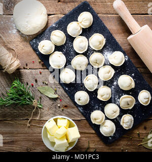 Vorbereitung, Kochen, die hausgemachten Ravioli, maultaschen oder Knödel mit Fleisch auf Holztisch, Ansicht von oben. Ansicht von oben. Im rustikalen Stil. Stockfoto