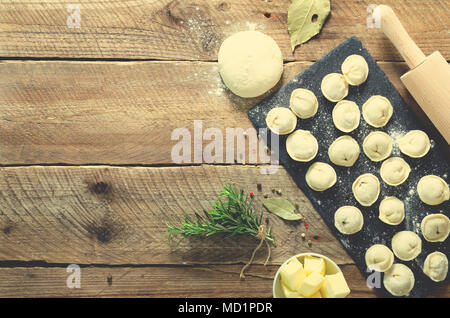 Vorbereitung, Kochen, die hausgemachten Ravioli, maultaschen oder Knödel mit Fleisch auf Holztisch, Ansicht von oben. Ansicht von oben. Im rustikalen Stil. Stockfoto