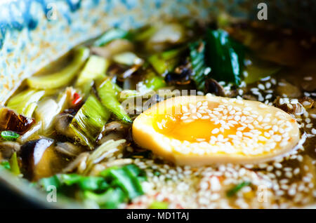 Ramen Suppe in der Schüssel. Reichen geschmack Hühnerbrühe mit Miso einfügen, gegrilltes Teriyaki Huhn, Lauch, Pilze, eingelegte Eier, Eiernudeln, Zwiebel, Chilli pe Stockfoto
