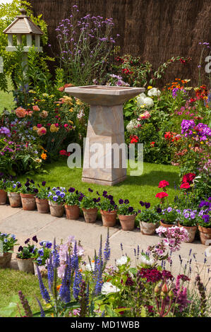 Farbenfrohe Sommer blühende Pflanzen auf Grenzen, Pfad & Stein birdbath - Englisch Cottage Garten Anzeige, RHS Flower Show, Tatton Park, England, Großbritannien Stockfoto