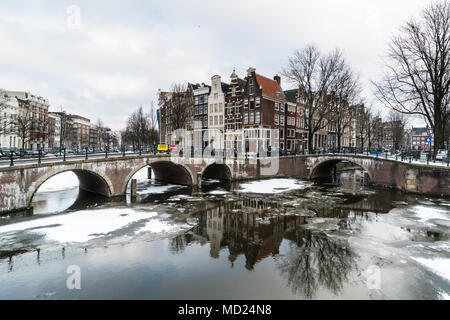 Atemberaubende Aussicht auf Amsterdam Canal mit Schnee während des Kalten wave im Februar 2018 auf einen sehr kalten Winter Tag eingefroren. Stockfoto