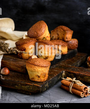 Runde gebackenen Muffins mit trockenen Früchten und Trauben auf einem braunen Holzplatte, schwarz Tisch Stockfoto