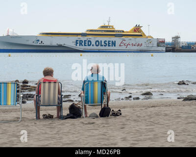 Ältere Paare sitzen in Liegestühlen am Strand mit Blick auf das Meer zu einem Fred Olsen Cruise Ship Santa Cruz de Tenerife, Spanien Stockfoto