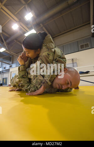 Us-Armee SPC. Danika Nolan entkommt dem HEADLOCK von Army Staff Sgt. Heriberto Nieves, während eine gemeinsame taktische Combatives Course, auf chièvres Air Base, Belgien, 9. März 2018. Nolan und Nieves sind mit der US-Armee Netzwerk Enterprise Center Belgien, 39 strategisches Signal Battalion. (U.S. Armee Foto von visuellen Informationen Spezialist Pierre-Etienne Courtejoie) Stockfoto