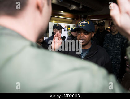 NORFOLK, Virginia (Mar. 16, 2018) - der Luftfahrt Bootsmann Mate (Ausrüstung) Airman Abriel Thomas, von Groesbeck, Texas, zu USS Gerald R. Ford's (CVN 78) Luft Abteilung zugewiesen, rezitiert die Eid der Rekrutierung von Leutnant Adam Boyd während Ihrer reenlistment Zeremonie gegeben. (U.S. Marine Foto von Mass Communication Specialist 3. Klasse Ryan Carter) Stockfoto