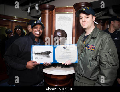 NORFOLK, Virginia (Mar. 16, 2018) - der Luftfahrt Bootsmann Mate (Ausrüstung) Airman Abriel Thomas, von Groesback, Texas, zu USS Gerald R. Ford's (CVN 78) Luft Abteilung zugewiesen, erhält ein Zertifikat, das von reenlistment von Leutnant Adam Boyd während Ihrer reenlistment Zeremonie. (U.S. Marine Foto von Mass Communication Specialist 3. Klasse Ryan Carter) Stockfoto