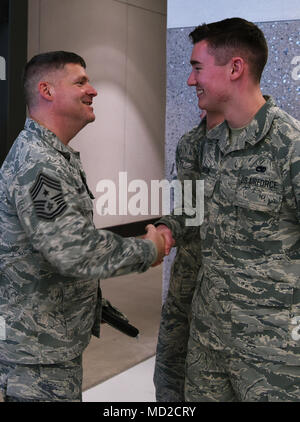 (Von links) Chief Master Sgt. Patrick McMahon, U.S. Strategic Command älterer Soldat Führer, rrecognizes Airman 1st Class Zachary Langum, 5 Aircraft Maintenance Squadron Mannschaft Leiter, am Minot Air Force Base, N.D., Jan. 12, 2018. Bei seinem Besuch, McMahon sprach mit 5 Bombe Flügel Flieger und besuchten Einrichtungen, darunter eine B-52 H Stratofortress Static Display, der Dakota Inn Speisesaal und andere Einrichtungen an der Basis. (U.S. Air Force Foto von Airman 1st Class Dillon J. Audit) Stockfoto