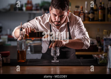 Barkeeper Vorbereitung Alkohol Cocktail trinken, Gießen rum Füllung einer jigger Stockfoto