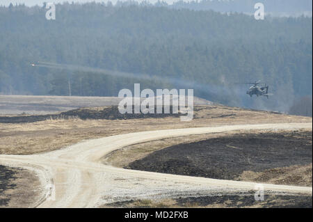 Eine AH-64D Apache longbow Helikopter mit Task Force Task Force Viper 1 Bataillon, 3 Aviation Regiment, 12 Combat Aviation Brigade Brände Hellfire Raketen während einer kombinierten Waffen live Fire übung mit 5 Squadron, 4th Cavalry Regiment, 2. gepanzerte Brigade Combat Team, 1.Infanterie Division bei der 7th Army Training Befehl Grafenwöhr Training Area, Deutschland, 26. März 2018. Stockfoto