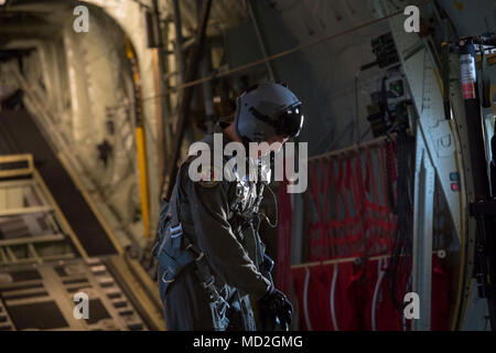 Airman 1st Class Matthew Pfeffer, 36th Airlift Squadron C-130J Lademeister, sichert seine Kabelbaum vor der Durchführung Container Delivery System (CDS) bundle Fallschirmabwürfen über kombinierte Waffen Training Center Camp Fuji, Japan, 26. März 2018. CDS werden am häufigsten für schnelle Antenne Einfügen von Verbrauchsmaterialien für militärische und Kontingenz Operationen verwendet. Die Bündel sind als Methoden zur Bereitstellung von Ausrüstung zu schwer für die einzelnen Jumper zu tragen. Stockfoto