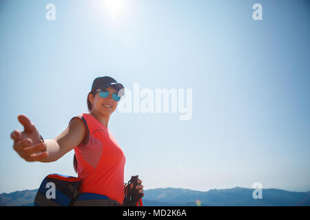 Foto von Frau touristische streckte die Hand gegen den Hintergrund der Berge und blauer Himmel Stockfoto
