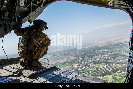 Spc. Sarah Henderson, ein flugingenieur mit der 3 Combat Aviation Brigade, 3 Infanterie Division, Scans, um die abgelegenen Gegenden von Jalalabad, Afghanistan, während auf die hintere Tür eines CH-47 Chinook Hubschrauber kauerte. Spc. Henderson die Flugzeuge, zugeordnet zu den Task Force Lighthorse, spielt eine wichtige Rolle im Zug, beraten und unterstützen Strategie für Afghanistan von fliegenden NATO-Koalition Berater mit ihren Afghanischen Kollegen zu arbeiten. Stockfoto