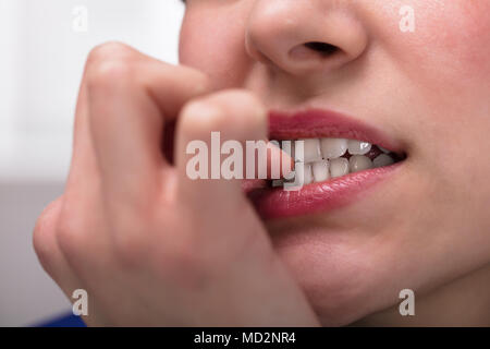 Nahaufnahme einer Geschäftsfrau beißen ihr Fingernagel Stockfoto