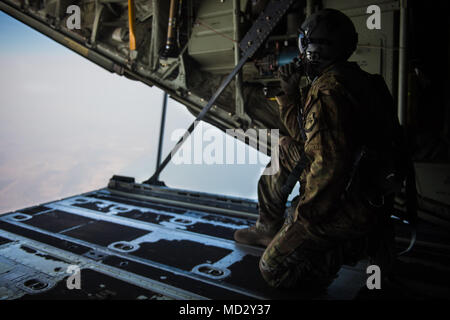 Ein US-Flieger von der 75th Expeditionary Airlift Squadron kauert auf der Rampe der C-130J Super Hercules in Dschibuti, Afrika, 10. April 2018. 75 EAS unterstützt die Combined Joint Task Force-Horn von Afrika Mission der Förderung des Wohlstands und der Sicherheit in Ostafrika durch Unterstützung der Partnerländer bei der Bekämpfung extremistischer Organisationen, die Förderung der regionalen Zusammenarbeit im Bereich der Sicherheit, und durch den Schutz von US-Personal und Einrichtungen in ihrem Zuständigkeitsbereich. (Usa Foto: Staff Sgt. Gustavo Castillo) Stockfoto