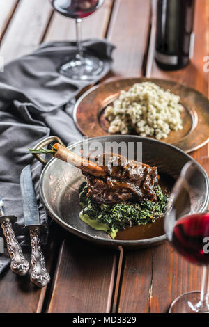 Geröstet oder Confit Lamm Bein in Pan mit Spinat und Rotwein. Stockfoto