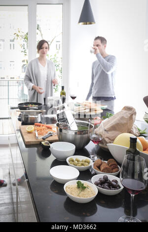 Selectiive Fokus - vegetarische Dips auf dem Tisch. Gruppe von Freunden sind, die zusammen kochen, beiläufig Snacking auf eine Auswahl von Lebensmitteln beim Lachen Stockfoto