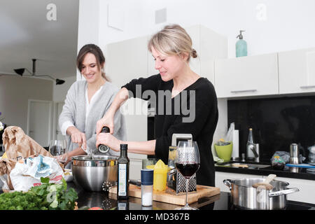 Gruppe von Freunden beiläufig Snacking auf eine Auswahl von Lebensmitteln beim Lachen und sich zu amüsieren. Stockfoto