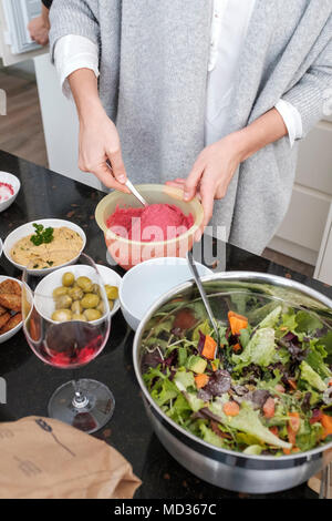 Frau Zubereitung rote Bete Hummus und Auswahl an vegetarischen Http://chromitierung.surtec.com - Gemischter Salat, grüne Oliven, Hummus Klassiker. Stockfoto