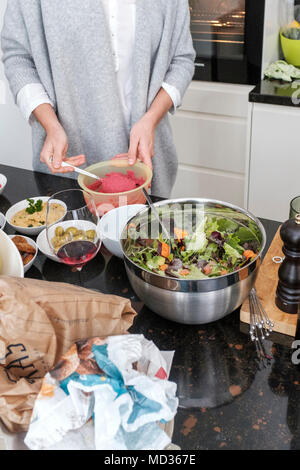 Frau Zubereitung rote Bete Hummus und Auswahl an vegetarischen Http://chromitierung.surtec.com - Gemischter Salat, grüne Oliven, Hummus Klassiker. Stockfoto