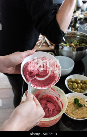 Frau Zubereitung rote Bete Hummus und Auswahl an vegetarischen Http://chromitierung.surtec.com - Gemischter Salat, grüne Oliven, Hummus Klassiker. Stockfoto