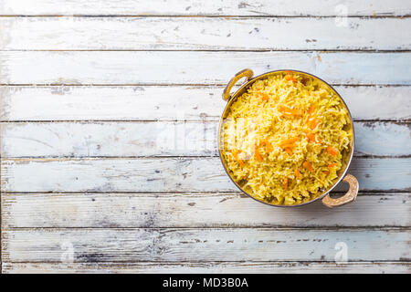 Basmati-reis mit gebratenen Curry in Edelstahl Kupfer über weiße Holz- hintergrund Pan, Ansicht von oben Stockfoto