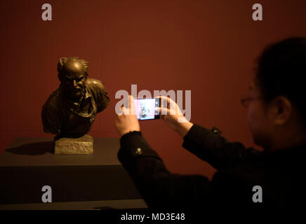 Peking, China. 18 Apr, 2018. Ein Besucher nimmt Fotos einer Skulptur Arbeit der Situ Jie schildert Norman Bethune, die bei der Ausstellung von Kunst von Situ Qiao und Situ Jie" im Nationalmuseum in Peking, der Hauptstadt von China, 18. April 2018. Die Ausstellung zeigt 80 funktioniert der Situ Qiao und Situ Jie, begann am Mittwoch. Credit: Jin Liangkuai/Xinhua/Alamy leben Nachrichten Stockfoto