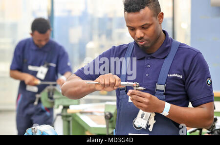 18. April 2018, Leipzig, Deutschland: Der lehrling Abdi Jamal Awal (R) Maßnahmen, die ein Werkstück in der Mechanik Zimmer im Training Center im BMW-Werk in Leipzig. Der deutsche Präsident Steinmeier und seine Frau nahmen an der Woche der Ausbildung, die unter der Überschrift "ran' erstellen Sie die Zukunft" (vom 16. bis 20. April 2018). Foto: Jan Woitas/dpa-Zentralbild/dpa Stockfoto