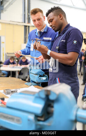 18. April 2018, Leipzig, Deutschland: Trainer Roy Grambow (L) im Gespräch mit Auszubildenden Abdi Jamal Awal im BMW-Werk in Leipzig. Der deutsche Präsident Steinmeier und sein Weib besuchte das Werk als Teil in der Woche der Ausbildung, die unter der Überschrift "ran' erstellen Sie die Zukunft" (vom 16. bis 20. April 2018). Foto: Jan Woitas/dpa-Zentralbild/dpa Stockfoto
