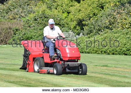Ein Mann auf einem Reiten-auf Rasenmäher, den Rasen zu mähen, ohne mit