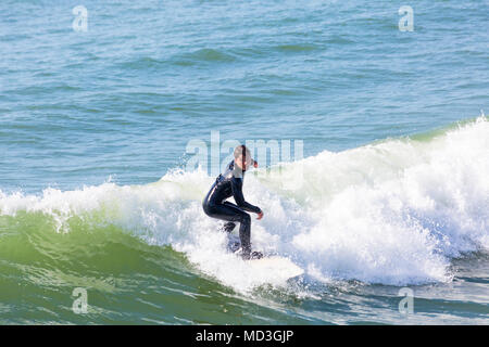 Bournemouth, Dorset, Großbritannien. 18. April 2018. UK Wetter: große Wellen bieten ideale Surfbedingungen am Strand von Bournemouth am heißesten Tag des Jahres so weit. In Aktion auf Surf Board einer Welle Surfer. Stockfoto