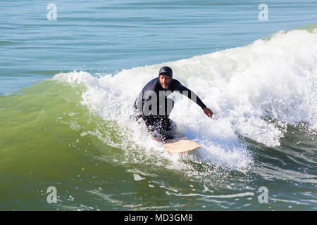 Bournemouth, Dorset, Großbritannien. 18. April 2018. UK Wetter: große Wellen bieten ideale Surfbedingungen am Strand von Bournemouth am heißesten Tag des Jahres so weit. In Aktion auf Surf Board einer Welle Surfer. Stockfoto