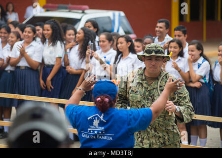Continuing Promise 2018 war eine humanitäre Mission der 4. US-Flotte in Mittel- und Südamerika im Jahr 2018. Am 16. März 2018 nahm ein Leichenbewohner des US-Navy-Krankenhauses an einem kulturellen Austausch mit einem Guia de Familia-Freiwilligen an der Franklin D. Roosevelt School in Puerto Cortes, Honduras teil. Das Archivbild dokumentiert die Community-Interaktion während der Bereitstellung. Stockfoto