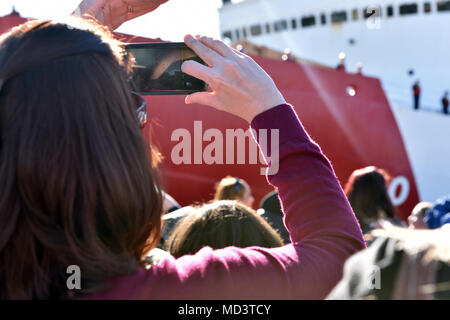 Ein Familie Mitglied nimmt ein Foto von einem Crewmitglied an Bord der Coast Guard Cutter Polar Star, wie die Mannschaft es Mauren zum Pier an der Basis Seattle, 16. März 2018. Das Seattle-based Polar Star Port im Dezember für die Antarktis links Operation Deep Freeze 2018 zu unterstützen, der Beitrag des US-Militärs in die US Antarctic Program, die von der National Science Foundation betrieben wird. U.S. Coast Guard Foto von Petty Officer 2. Klasse Ali Flockerzi. Stockfoto