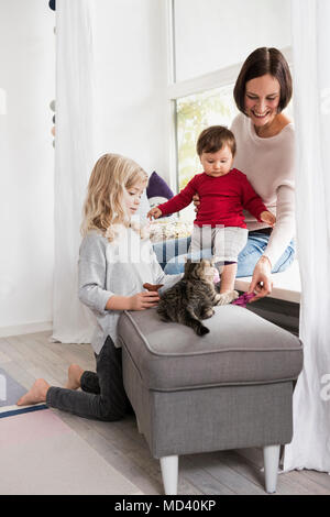 Mutter und zwei Töchtern spielen mit Haustier Katze Stockfoto