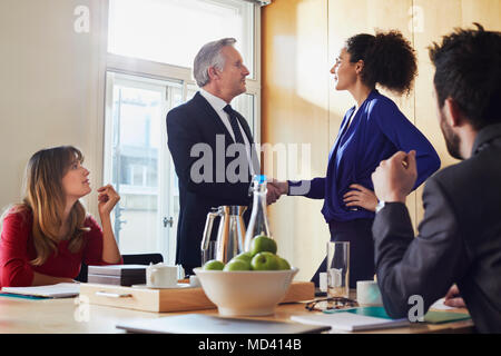 Geschäftsfrau und Menschen die Hände schütteln im Büro treffen Stockfoto