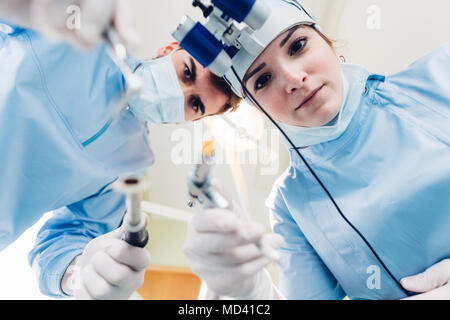 Zahnarzt und zahnmedizinische Krankenschwester behandeln Patienten, die persönliche Perspektive Stockfoto