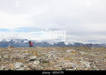 Fernsicht auf Mann mit Kindern wandern Bergwelt, Nationalparks Jotunheimen, Lom, Oppland, Norwegen Stockfoto