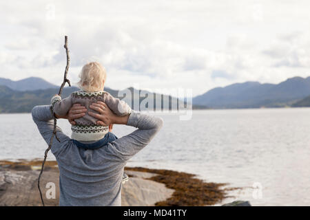 Mann und Sohn mit Blick auf Fjord, Aure, Mehr og Romsdal, Norwegen Stockfoto